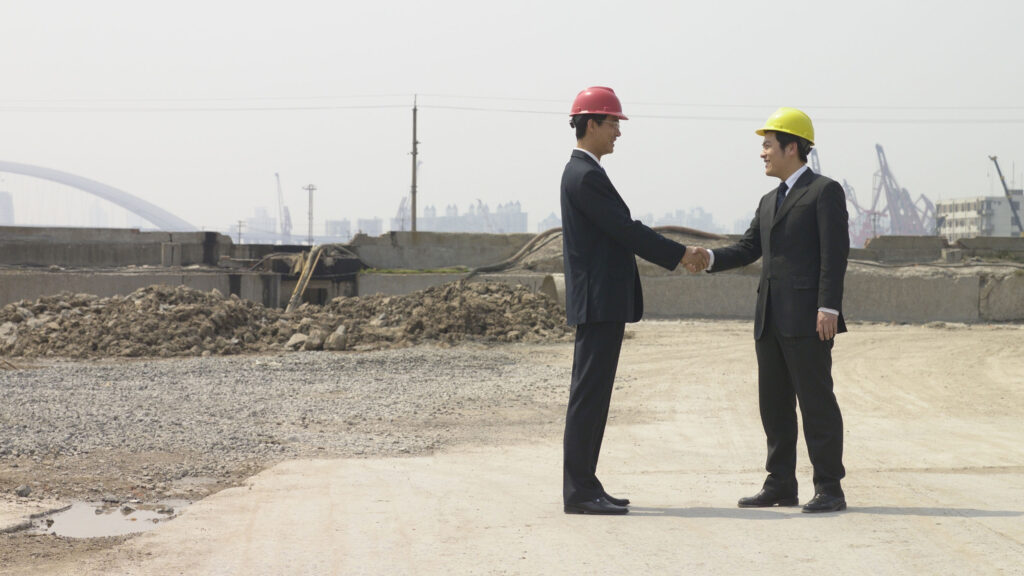 Businessmen shaking hands at a construction site